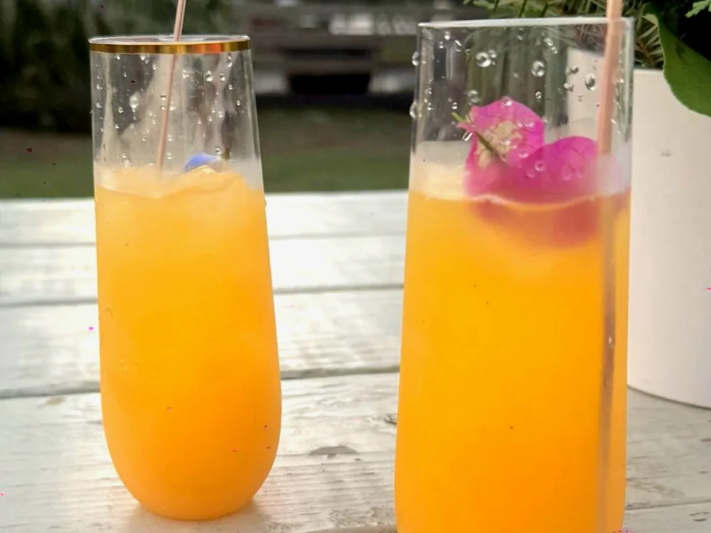 Dos mimosas decoradas con flores, servidas en una despedida de soltera